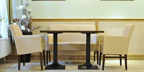 Čalouněn&eacute; křeslo Laura v interi&eacute;ru restaurace.