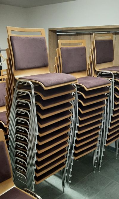 Kovové židle s čalounněím a možností stohování pro kulturní domy 