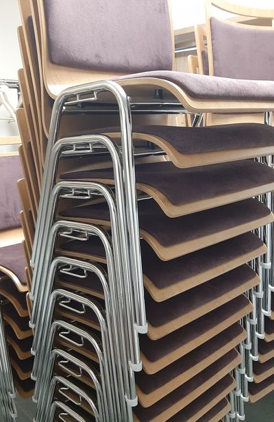 Kovové židle s čalounněím a možností stohování pro kulturní domy 