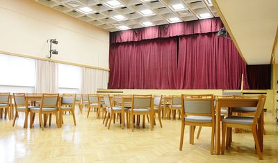 Stohovatelné čalouněné židle a stoly do kulturního domu